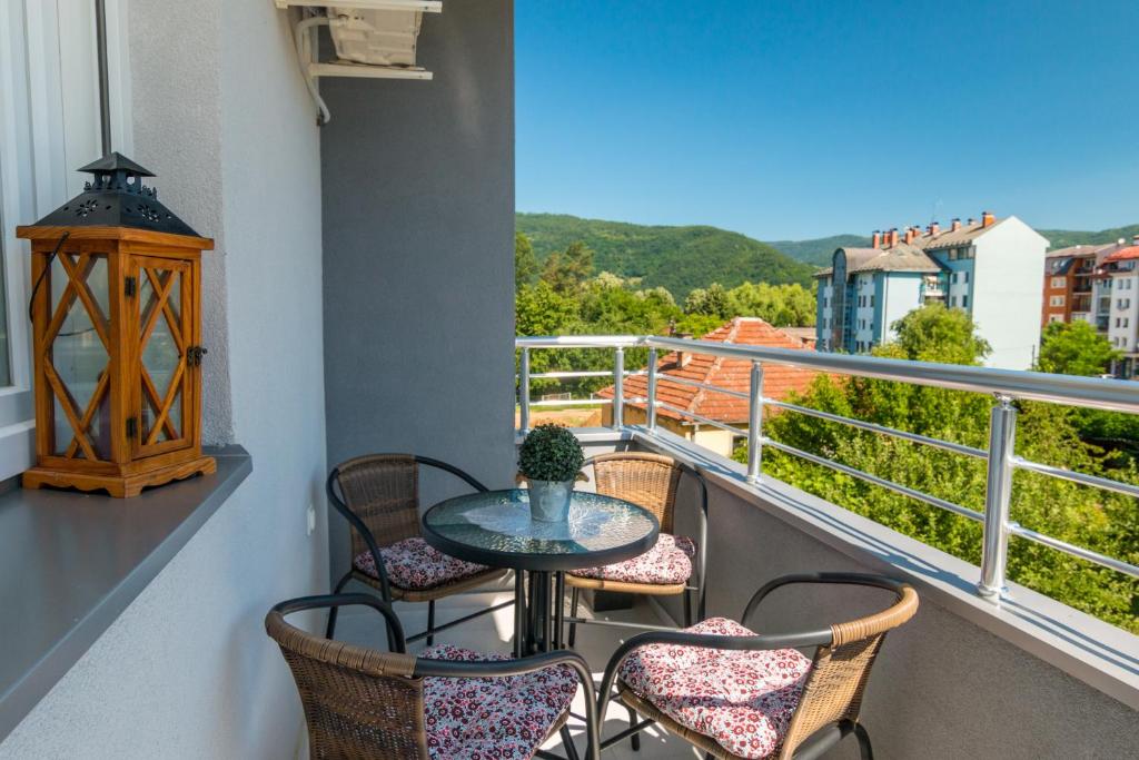 balcone con tavolo, sedie e vista di Apartman Agin Kutak a Bajina Bašta