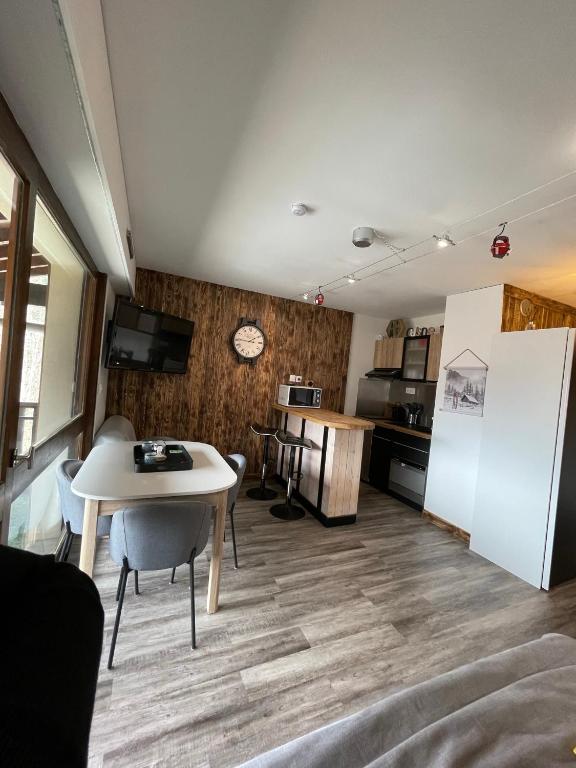 une cuisine avec une table et un réfrigérateur blanc dans l'établissement Superbe studio de montagne entièrement rénové, à Morzine