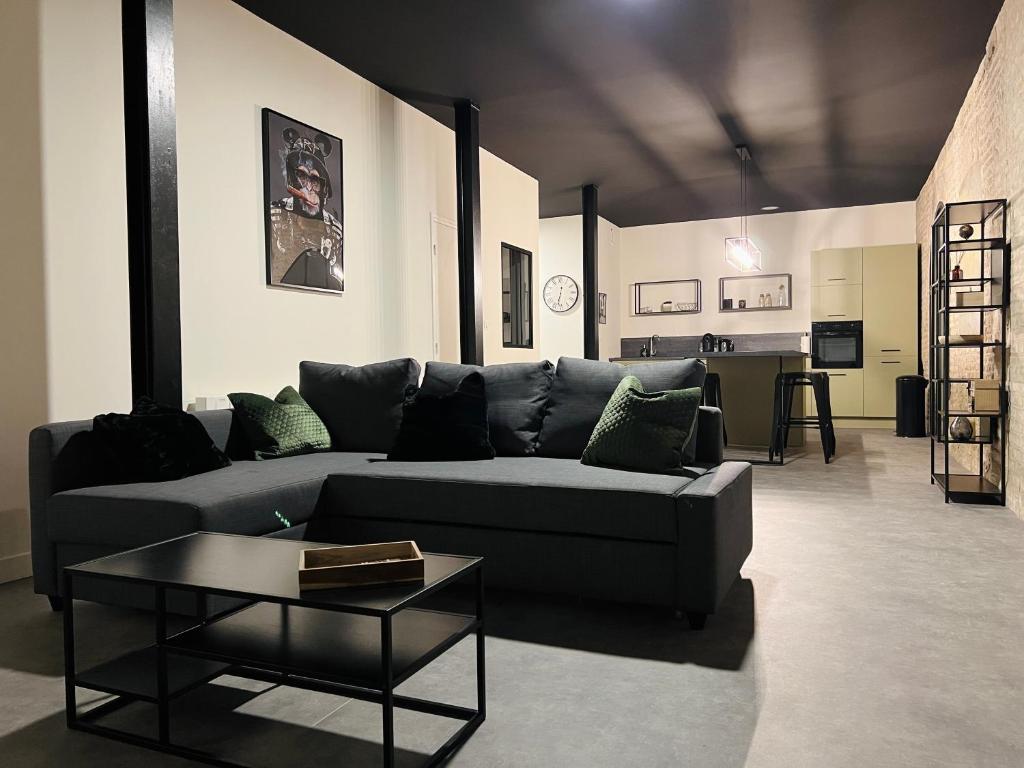 a living room with a couch and a table at Loft atypique Dunkerque Centre in Dunkerque