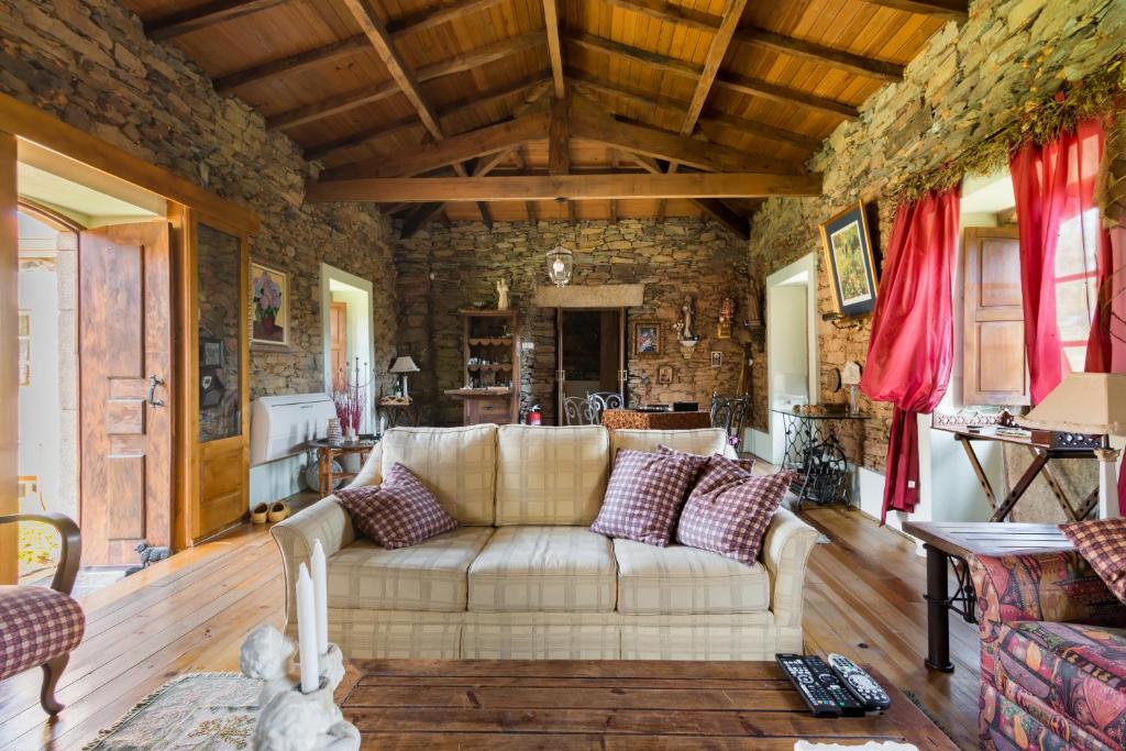 uma sala de estar com um sofá e uma parede de pedra em R3 Service - Quinta da Melroa - Mountain Villa em Viseu