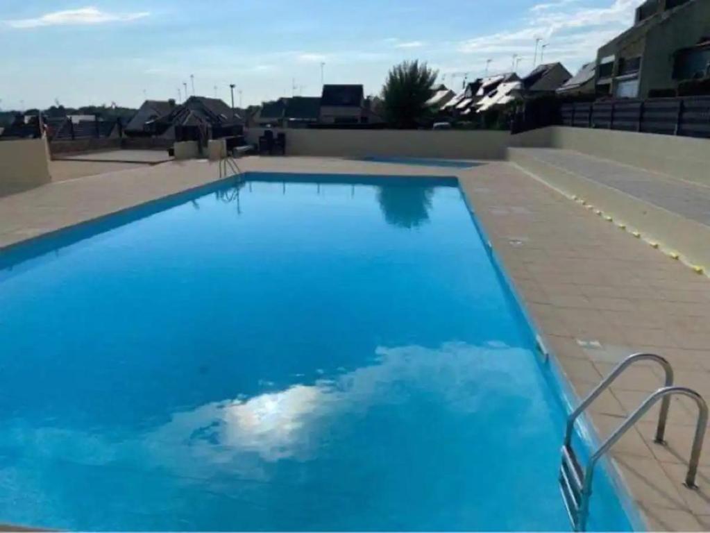 een groot blauw zwembad bovenop een gebouw bij Petite maison avec piscine à 500m de la plage in Guidel