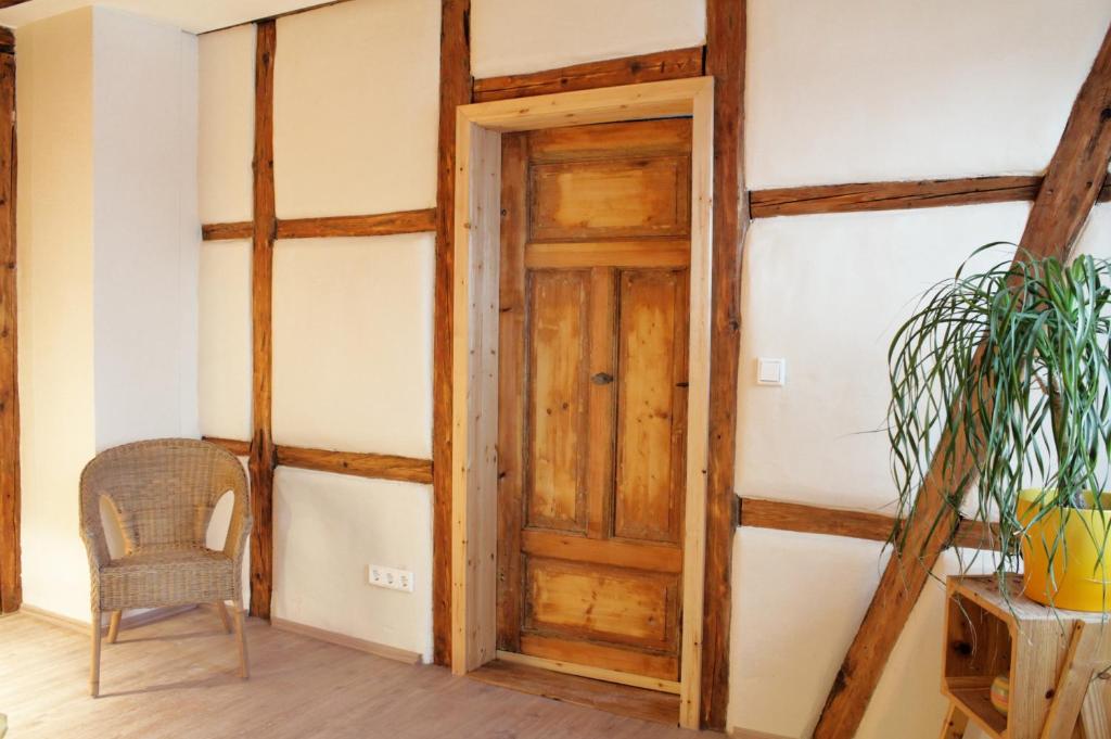 een kamer met een houten deur en een stoel bij Haus 1813 in Erfurt