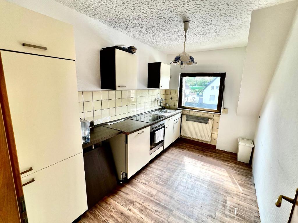 uma cozinha com electrodomésticos brancos e piso em madeira em Praktisches Zimmer im Großen Haus mit garten em Dusseldorf