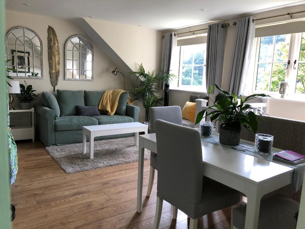 uma sala de estar com uma mesa e um sofá em The Nest Danehill em Haywards Heath