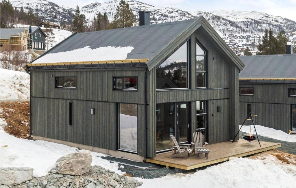 a green house with a deck in the snow at Beautiful Home In Rauland With House A Mountain View in Rauland