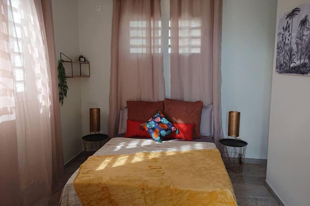 una camera da letto con un letto con una coperta gialla sopra di Héritage créole 3 : Touloulou a Sainte-Luce