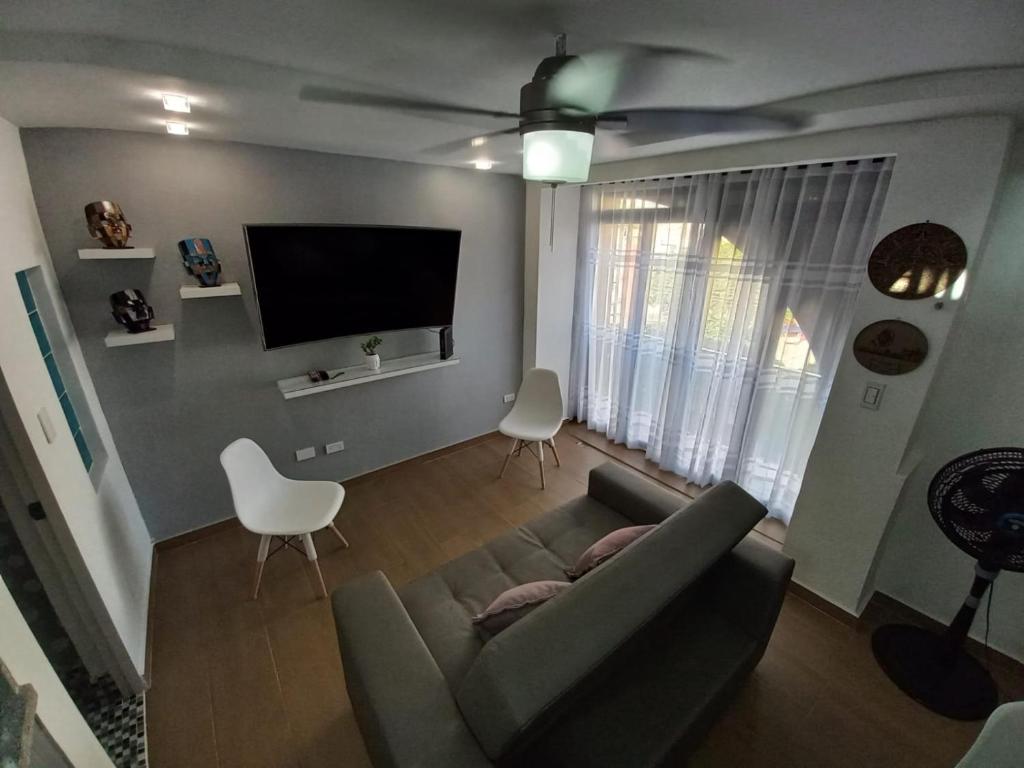 sala de estar con sofá y TV de pantalla plana en Apartamento dúplex vacacional cerca a la playa, en Gaira