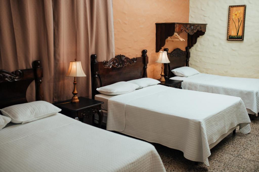 a hotel room with two beds and two lamps at Hotel Condesa in Comayagua