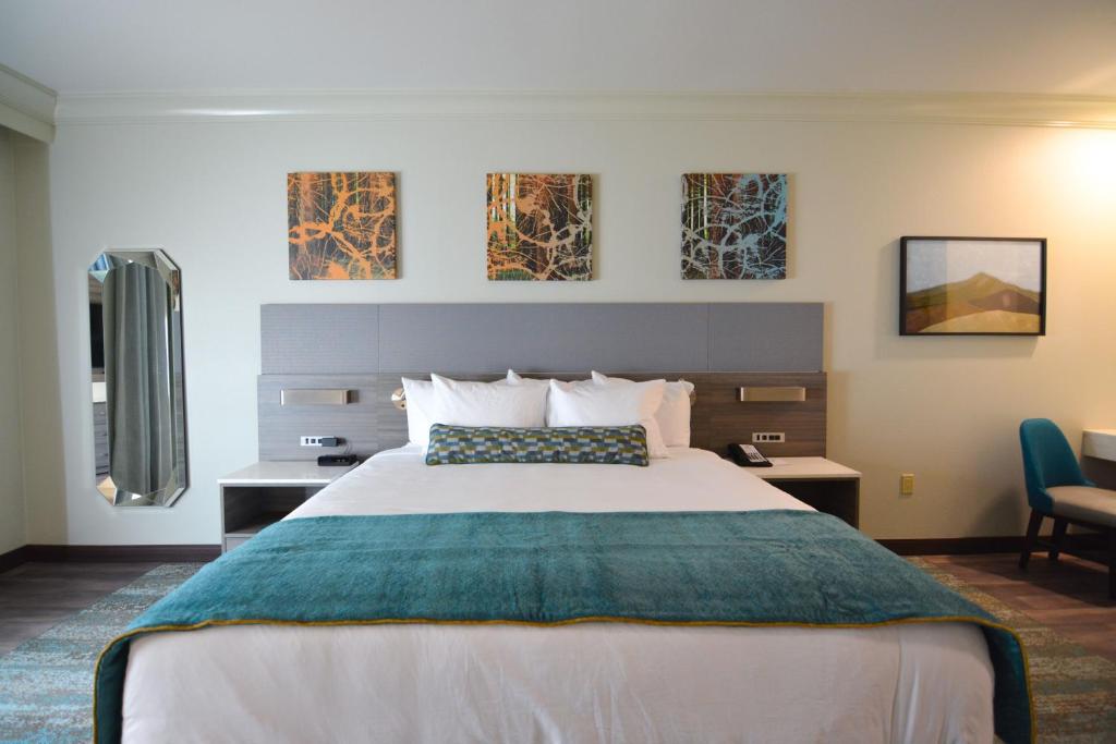 ein Hotelzimmer mit einem großen Bett und zwei Stühlen in der Unterkunft Blue Lake Casino and Hotel in Blue Lake