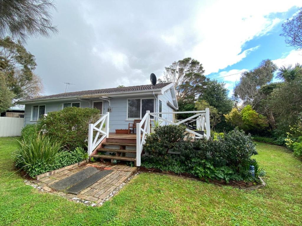 a small white house with a porch and stairs at Invy Escape in Inverloch