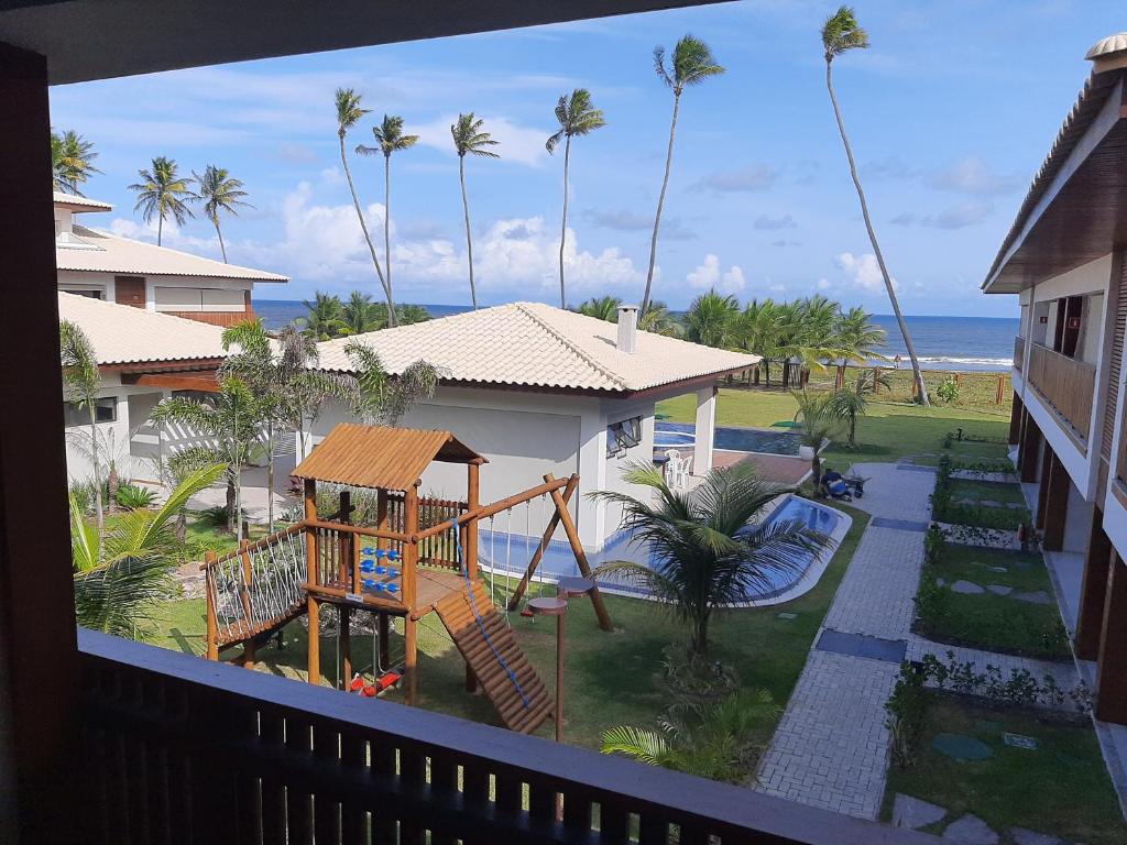a view from a balcony of a resort with a playground at Itacimirim - Duplex Aconchegante, Pé na Areia in Itacimirim