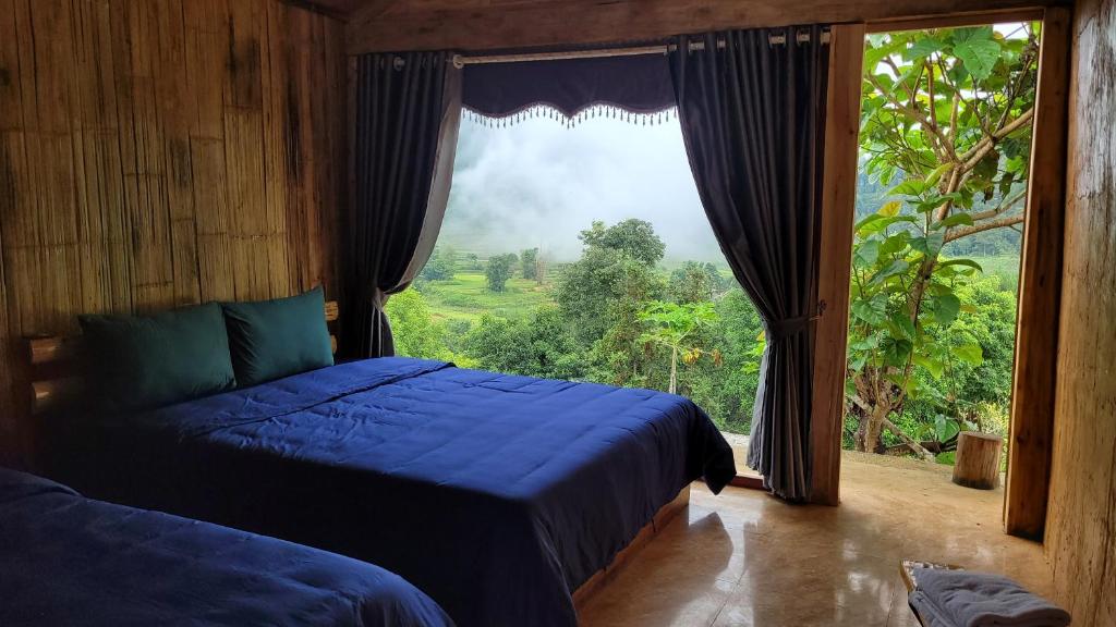 a bedroom with a bed and a large window at Toong homestay in Ha Giang