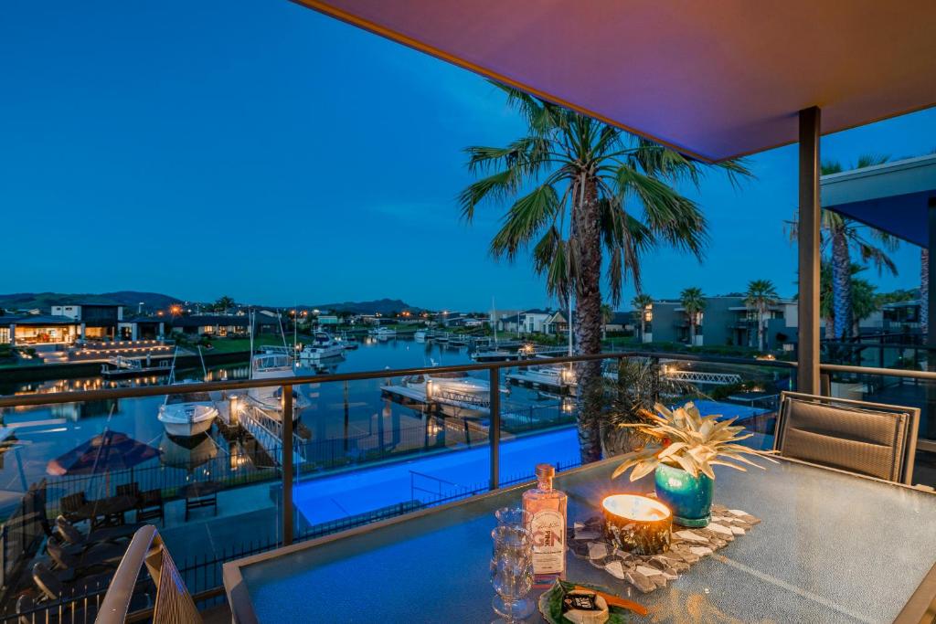 einen Balkon mit einem Tisch und Hafenblick in der Unterkunft Waterways Serenity in Whitianga