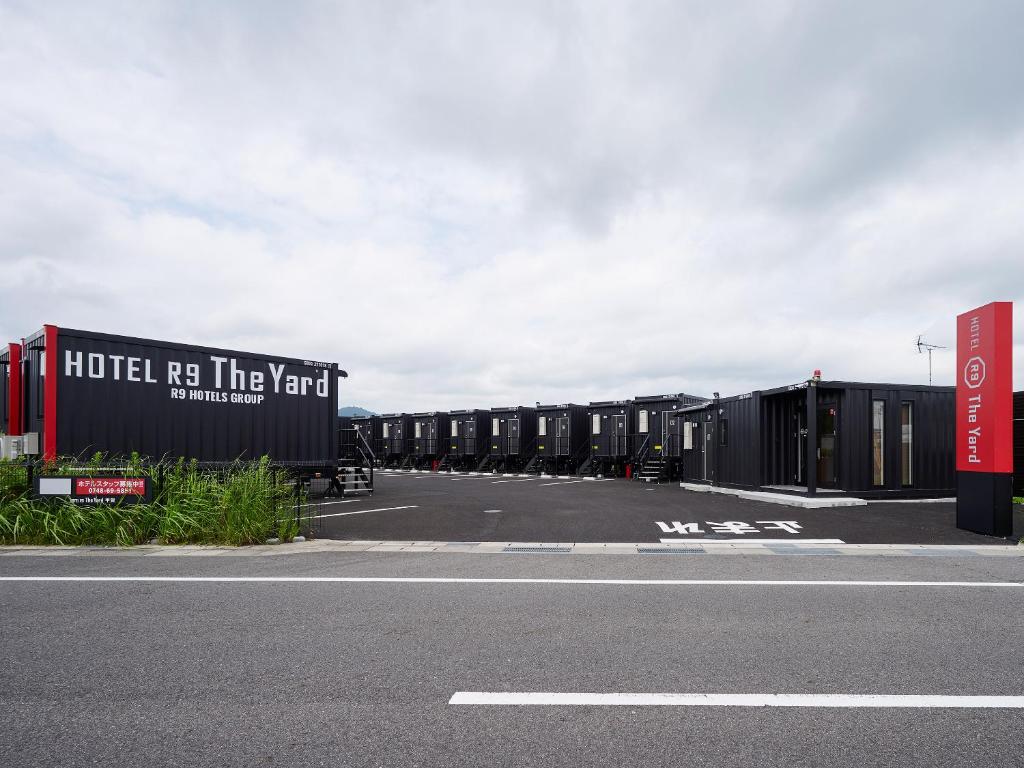 a row of shipping containers in a parking lot at HOTEL R9 The Yard Koka in Koka
