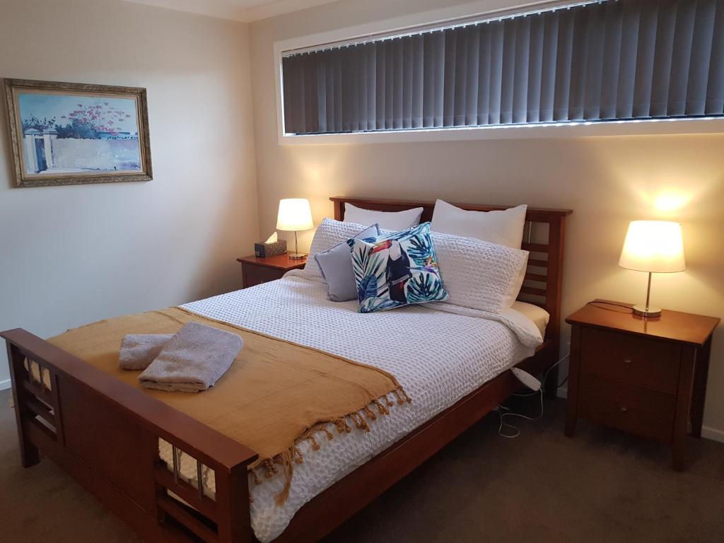 1 dormitorio con 1 cama grande con almohadas y 2 lámparas en Torquay Homestay Guesthouse en Torquay