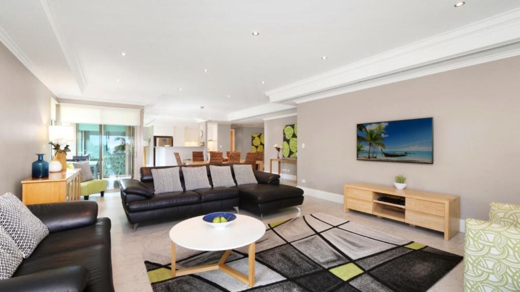 uma sala de estar com um sofá e uma mesa em Unit 40 - 4 Bed Part Ocean View em Terrigal