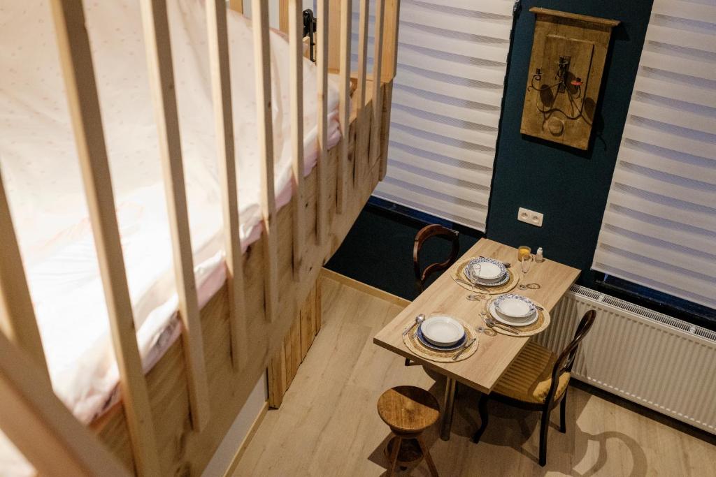 uma pequena mesa e cadeiras num quarto com uma cama em Le Studio Émeraude - Topdestination-Spa em Spa