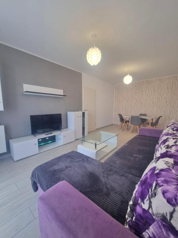 a living room with a purple couch and a table at Best View Apartment in Braşov