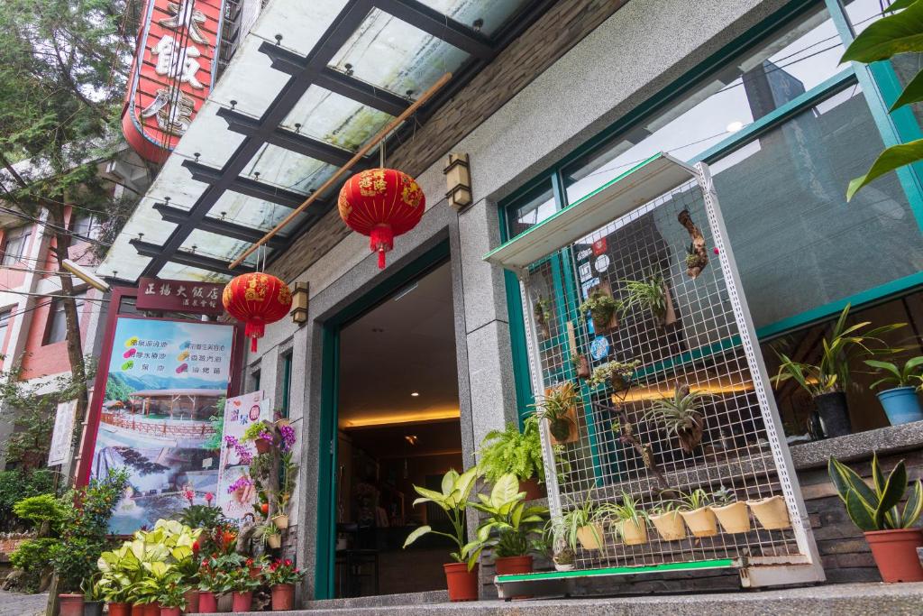 uma frente de loja com lanternas vermelhas e plantas nele em Jenq Yang Hotspring Hotel em Renai