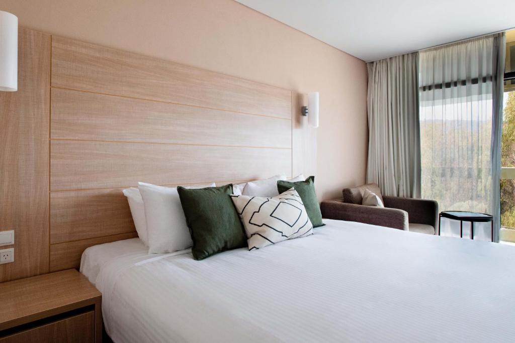 Un dormitorio con una cama grande y una ventana en The Terrace Hotel Adelaide, en Adelaida