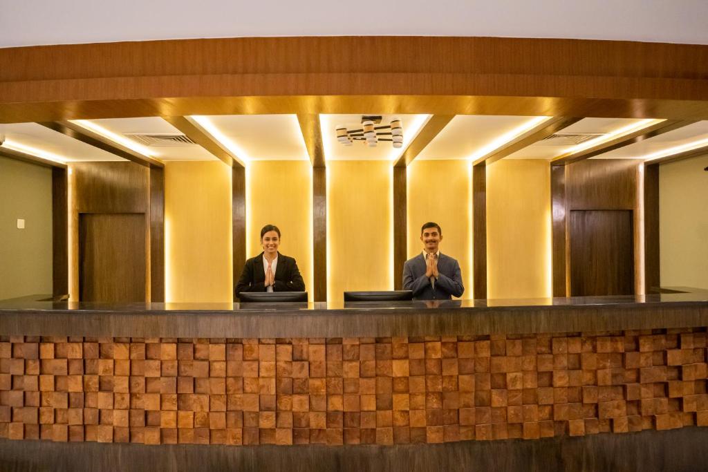 Due uomini seduti al bancone di fronte agli specchi di Soaltee Westend Resort Chitwan a Chitwan