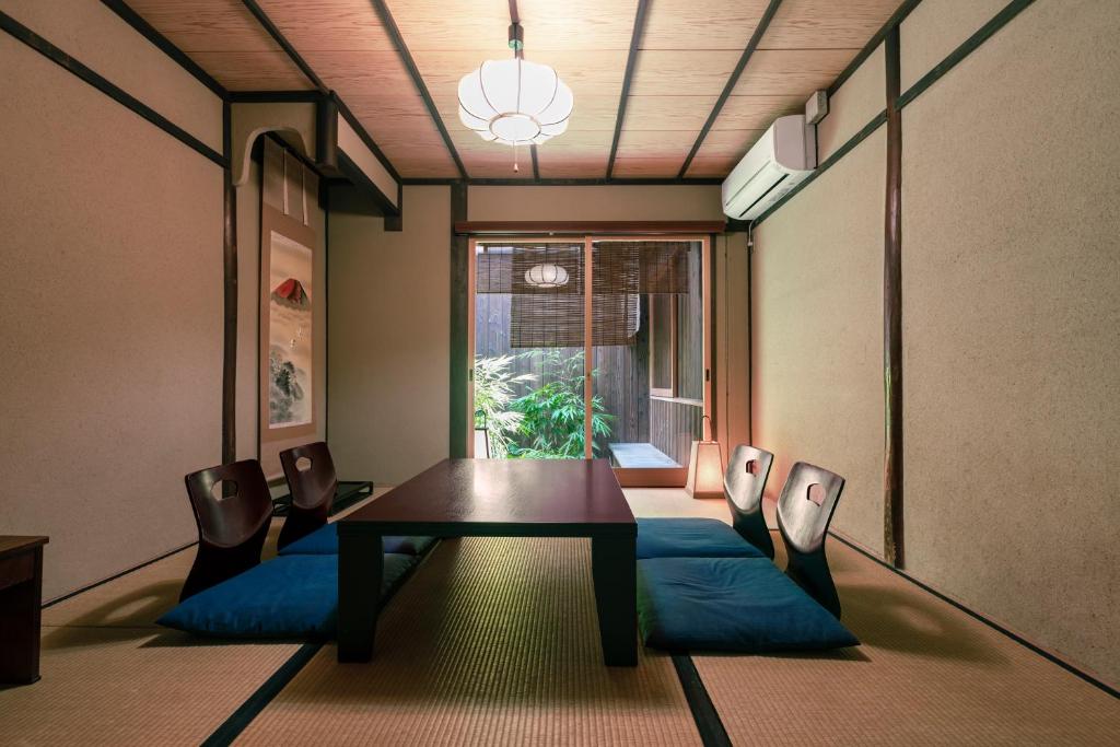 京都Rinn Nishiwakamatsu的一间有桌子、椅子和窗户的餐厅