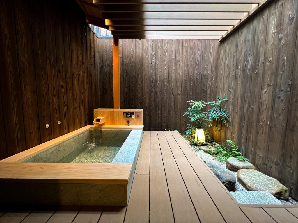uma banheira de hidromassagem numa casa com jardim em Rinn Rokujo Machiya em Quioto