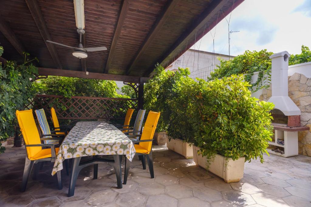 een patio met een tafel en stoelen onder een dak bij Villa Rita a 200m dal mare in I Bacini