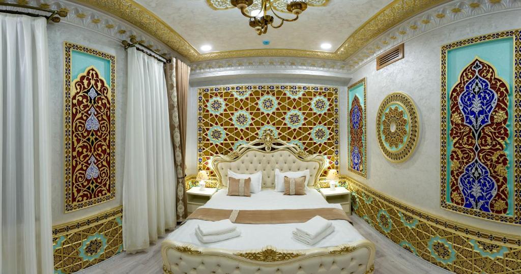 布哈拉的住宿－Asian Plaza，卧室设有一张大床,卧室拥有色彩缤纷的墙壁