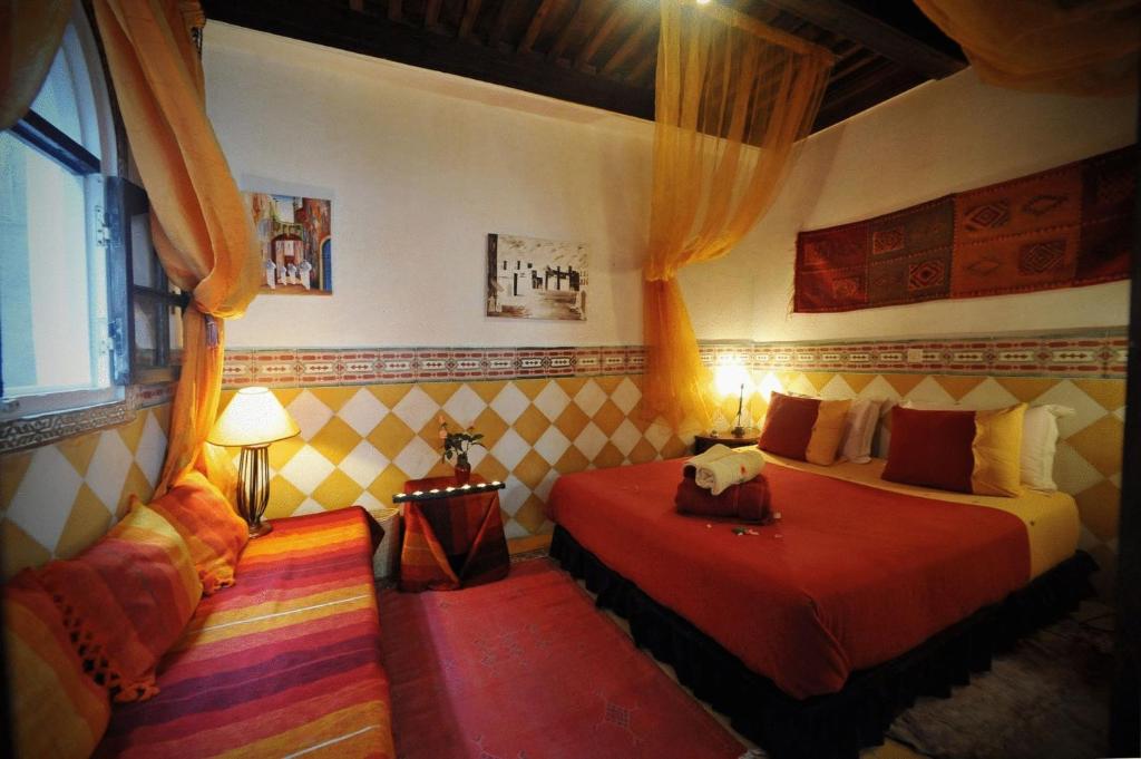a bedroom with two beds and a window at Dar El Paco in Essaouira