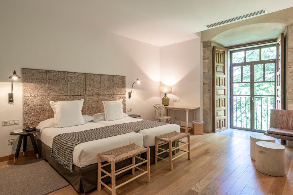 Habitación grande con cama grande y escritorio. en Parador de Corias, en Cangas del Narcea