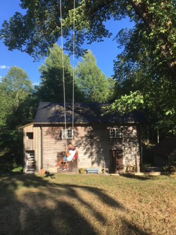 Una donna in piedi di fronte a una piccola casa di Henneviken BnB a Ed