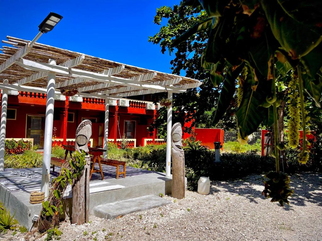 a pergola with a red building in the background at Elluk East Studios in Port Vila