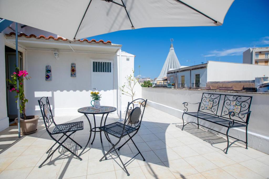 um pátio com uma mesa e cadeiras numa varanda em Casa ToRi em Siracusa