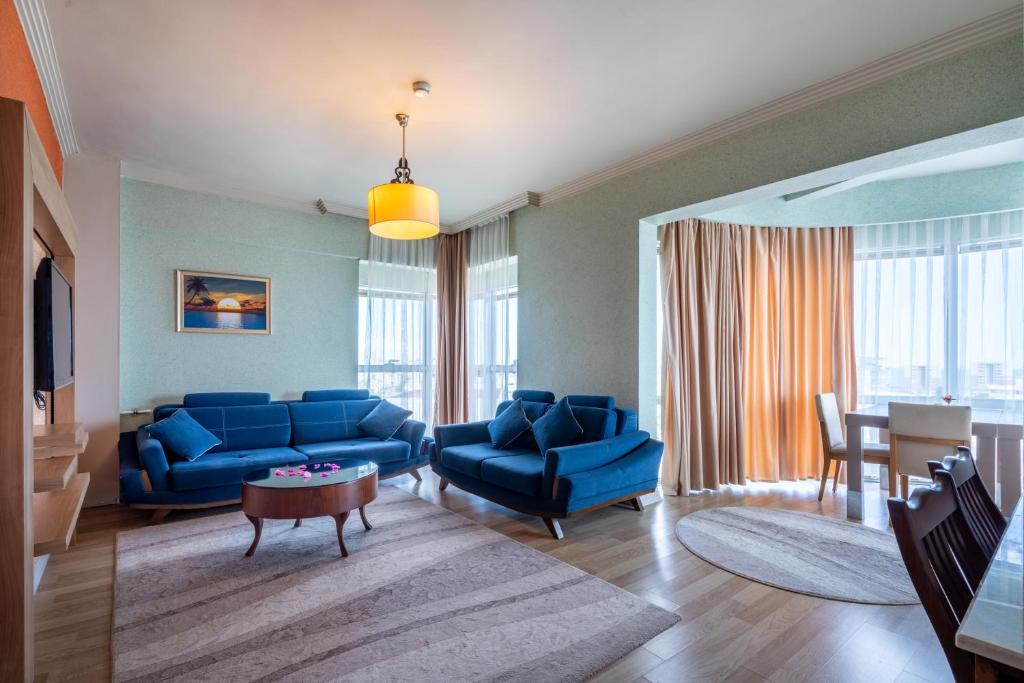 a living room with blue couches and a table at City Live Hotel in Antalya