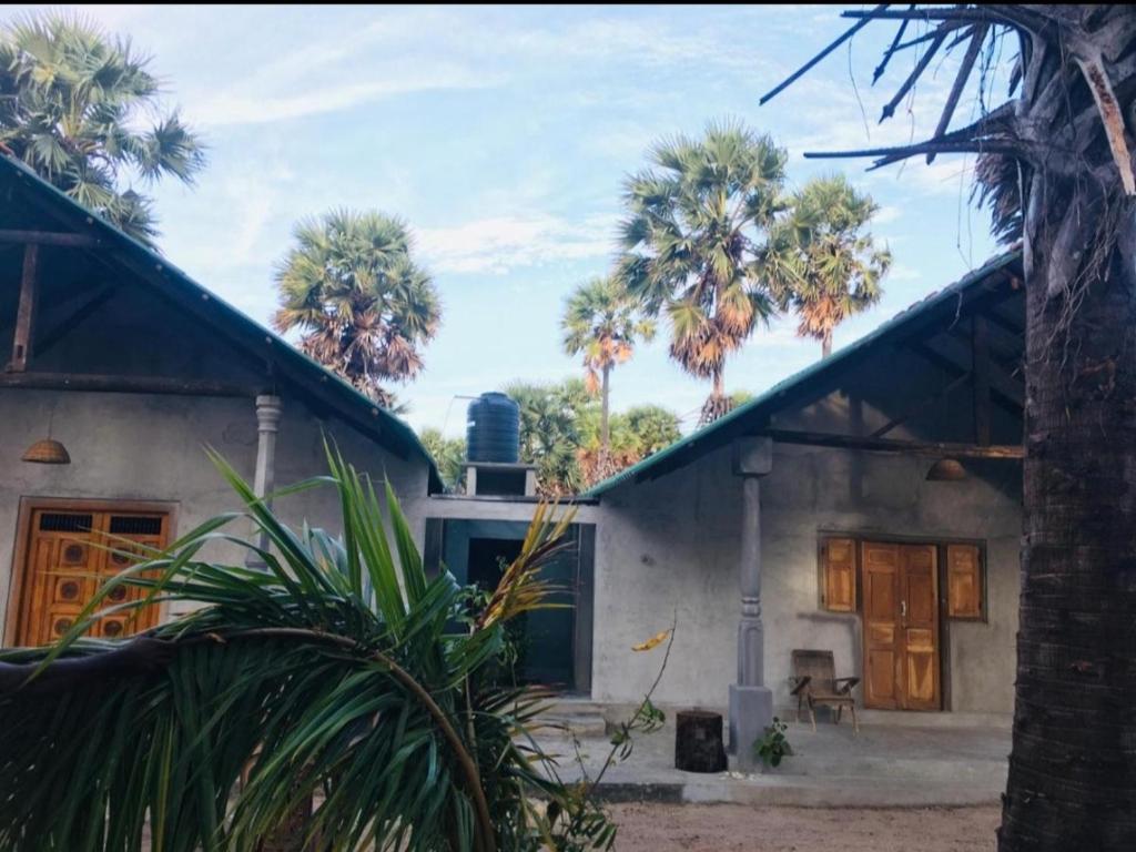 una casa con palme di fronte di Malabar Beach Walk a Jaffna