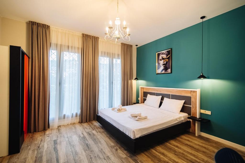 a bedroom with a bed and a green wall at Wine Rock Hotel in Tbilisi City