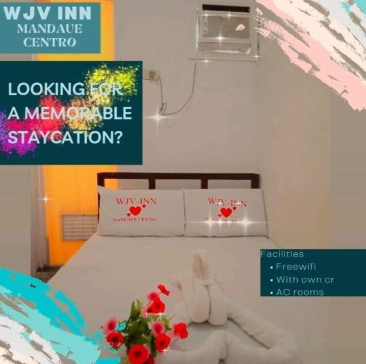 a bedroom with a bed with red flowers on it at WJV INN Mandaue Centro in Mandaue City