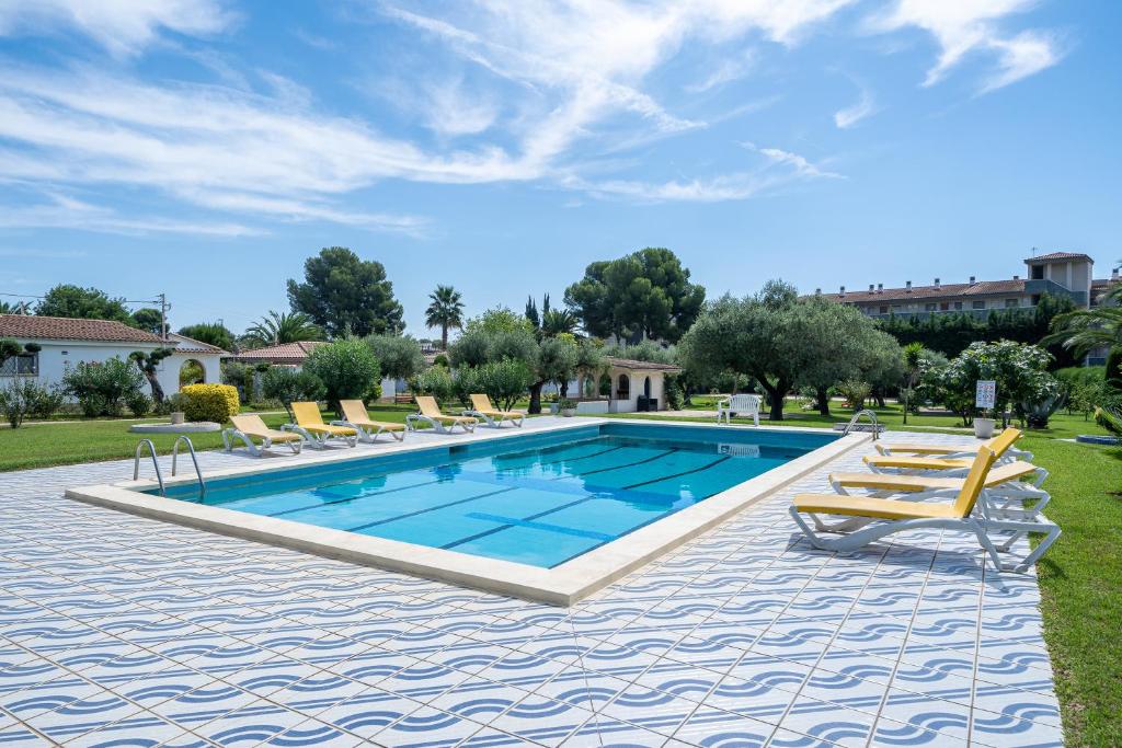 einen Pool mit Liegestühlen und einem Pool in der Unterkunft Villa La Palmera in Cambrils