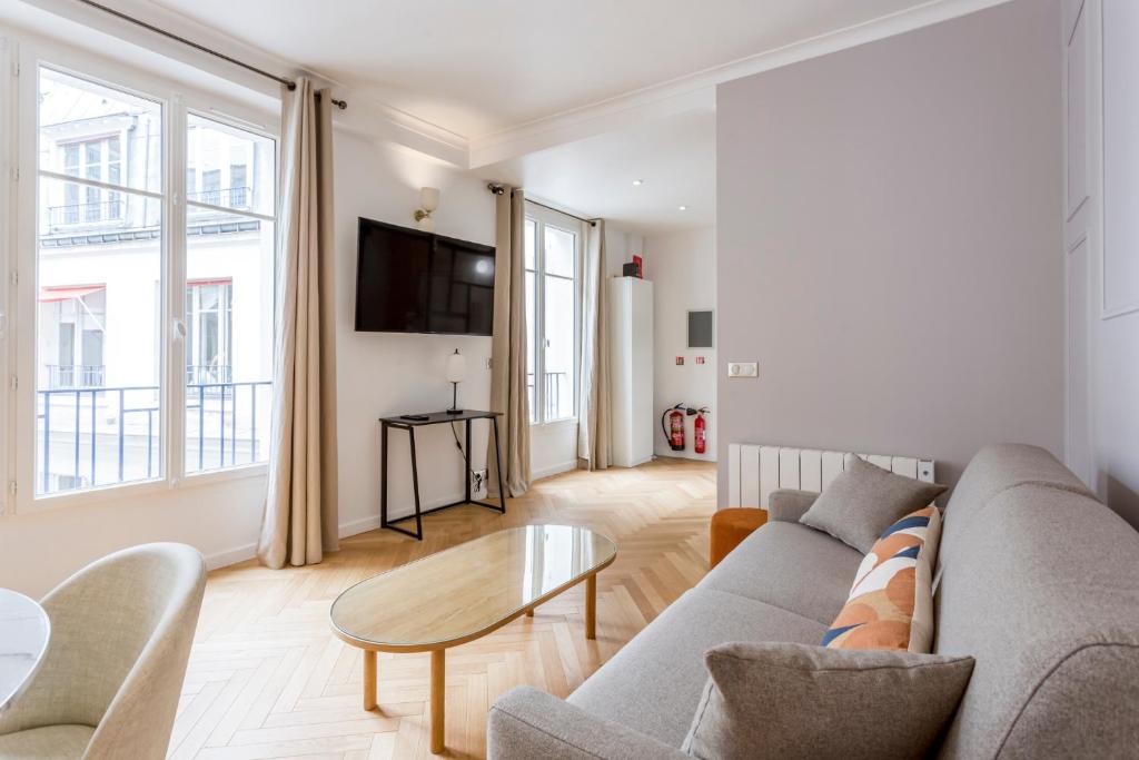 a living room with a couch and a table at Reva Suites in Paris