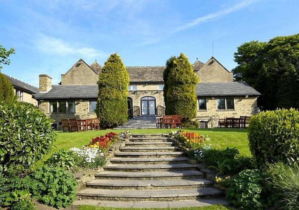 Cette grande maison en pierre est accessible par des escaliers. dans l'établissement The Old Golf House Sure Hotel Collection by Best Western, à Huddersfield