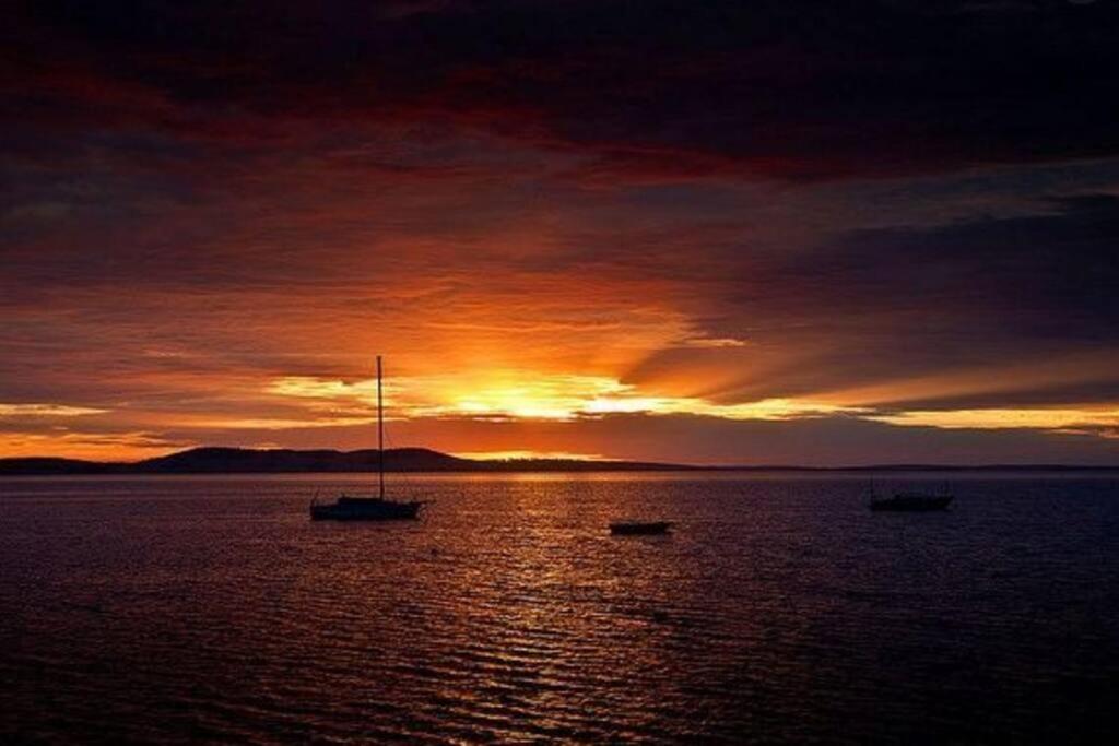 a sunset with three boats in the water at H&H studio overlooking Boston Bay, Port Lincoln in Port Lincoln