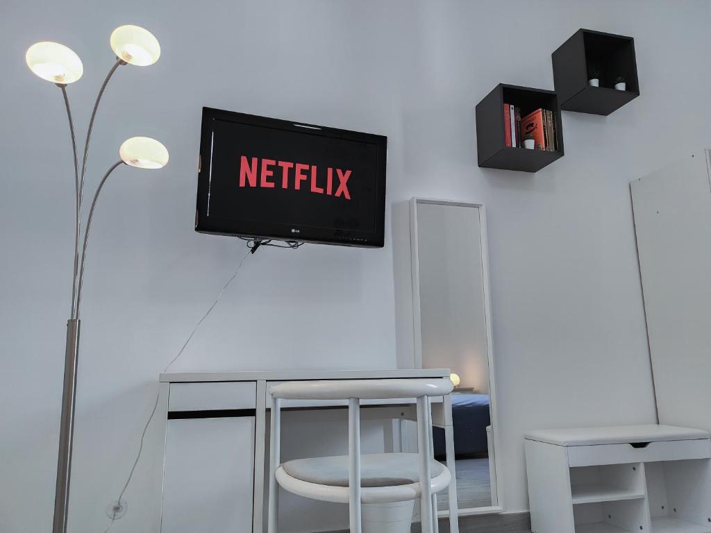 telewizor na ścianie ze stołem i stołkiem w obiekcie S&M Apartments "Casa Gemma" - Cimiano M2 w Mediolanie