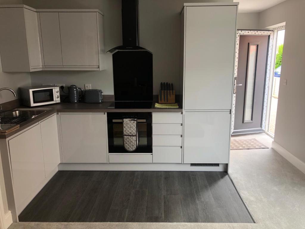 a kitchen with white cabinets and an oven at New ground floor 2 bed flat close to the beach in Southbourne