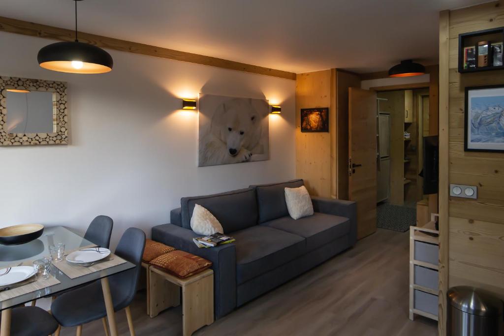 een woonkamer met een bank en een tafel bij Courchevel 1550 - SUPERBE appartement SKIS AUX PIEDS ! in Courchevel