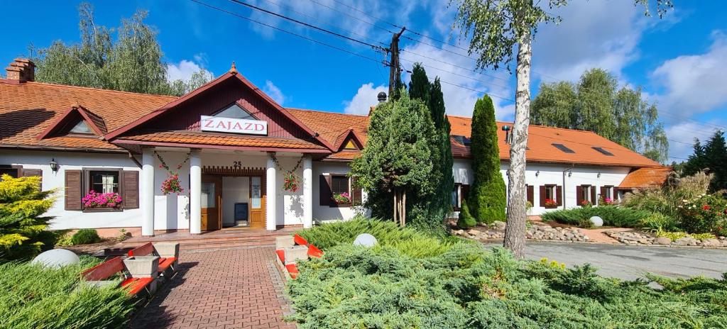 une maison avec un panneau à l'avant dans l'établissement Motel i Restauracja "Pod Basztą", à Nagłowice