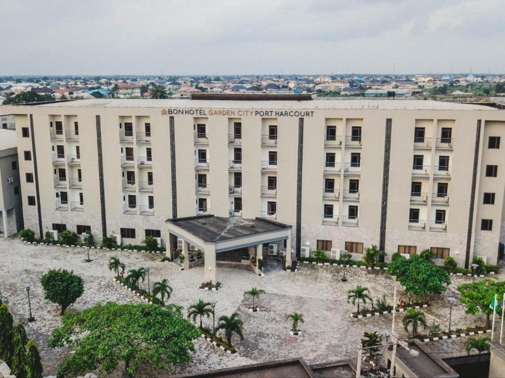 a large white building with a courtyard in front of it at BON Hotel Garden City Port Harcourt in Umudara