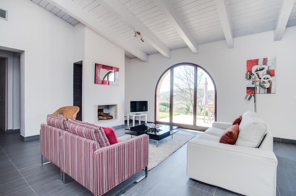 uma sala de estar com dois sofás e uma televisão em Superior apartment with terrace em Petroio