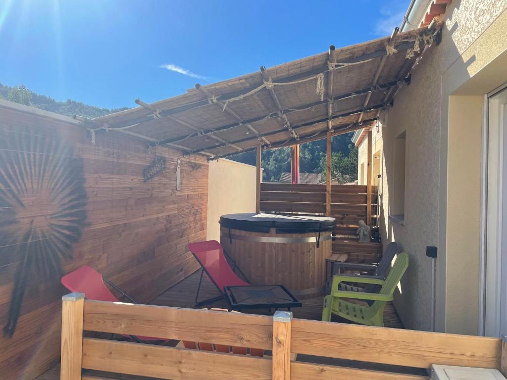 une terrasse avec une clôture en bois, des chaises et un tonneau dans l'établissement Gite La Dolce Vita, aux Ollières-sur-Eyrieux