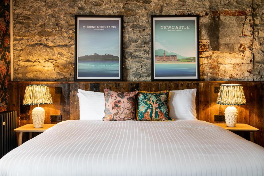 a bedroom with a white bed with two lamps at Avoca Hotel in Newcastle